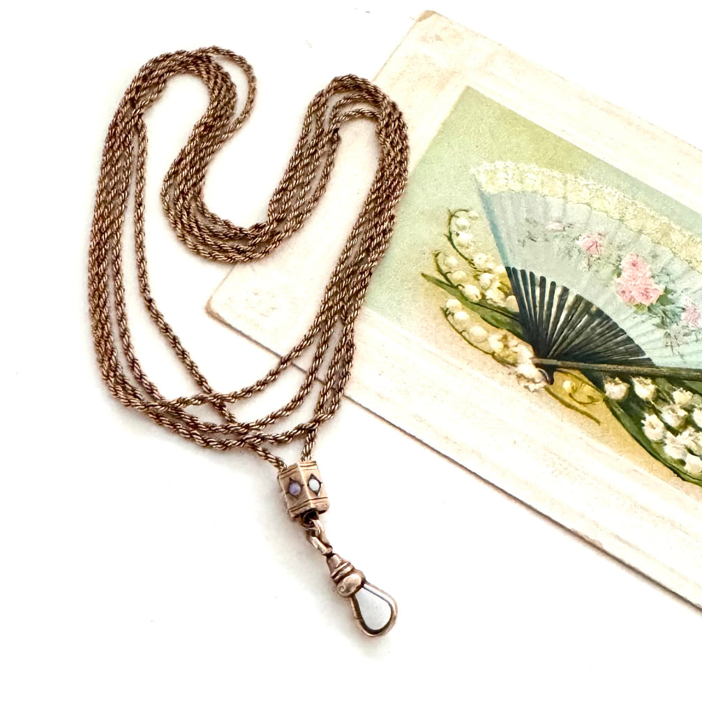 Antique A.H.B & C rolled rose gold guard chain with opal slider on an old postcard.