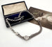 Antique albertina chain on a white background and with an old postcard and box