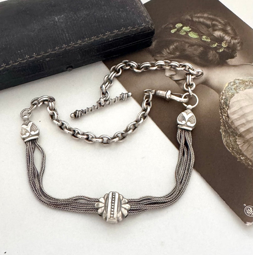 Antique albertina chain on a white background and with an old postcard and box