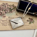 Vonk Jewellery antique 1909 arts and crafts stamp case necklace on a vintage postcard with purple flowers and a vintage jewellery box