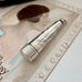 Antique silver cheroot holder case on an old postcard of a woman.