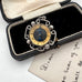 Decorative antique compass in an open box with a vintage card underneath