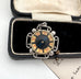 Decorative antique compass pendant with a circular design in a black case on a white background