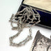 Antique silver fancy link guard chain on an old jewellery box and with an engraved picture in the corner