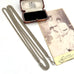 A vintage silver plated guard chain necklace with a lobster clasp, displayed next to its open wooden presentation box and an antique sepia-toned portrait photograph on a white background.