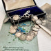 Silver coin bracelet with antique British threepence coins in an open jewelry box on a floral surface.