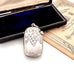 Antique silver vesta case pendant with floral design on an old advertising card and an open box.