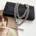 Antique silver watch chain necklace on an old jewellery box and with an old postcard