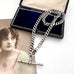 Antique silver watch chain necklace on an old jewellery box and with an old postcard