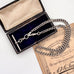 Antique silver watch chain necklace on an antique advertising card and a vintage jewellery box