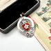 Antique silver and red enamel watch fob on an open jewellery box.