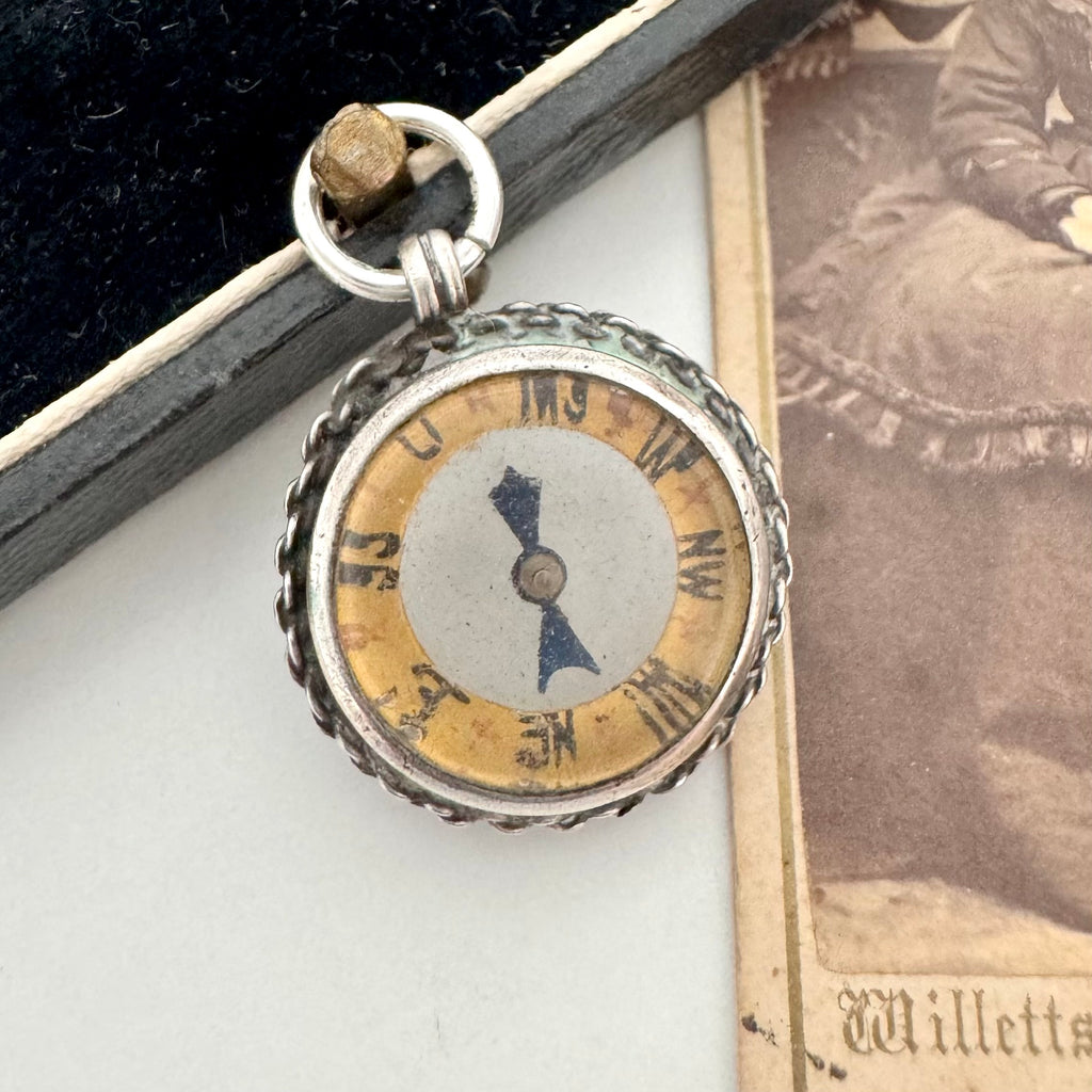 Antique silver compass watch fob  on an old photograph
