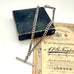 Antique sterling silver watch chain necklace on an old jewellery box and with some advertising material for a Victorian London Photographers studio.