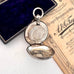 Silver antique sovereign holder in an open box with a document on a white surface