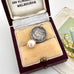 Antique 1891 threepence and pearl rop charm on an old jewellery box