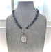 1887 sterling silver vesta case and peacock pearl necklace on a grey mannequin
