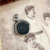 Antique victorian albo silver carnelian and bloodstone spinning fob displayed on top of a vintage sepia-toned photograph.