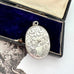 Antique Victorian era silver locket with an engraving of an urn and an old jewellery box