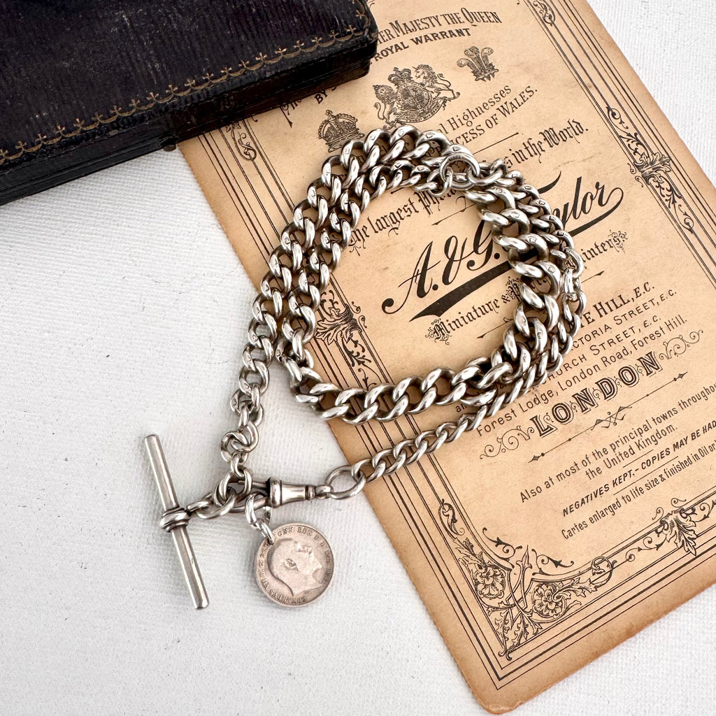 Antique watch chain and coin necklace on an old document