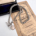 Antique watch chain and coin necklace on an old document and with an old jewellery box