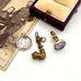 Three vintage-style pendants on a white surface with an old photograph and jewelry box.