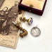 Vintage-style jewelry including a brooch, pendant, and ring box on a white surface with an old photograph.
