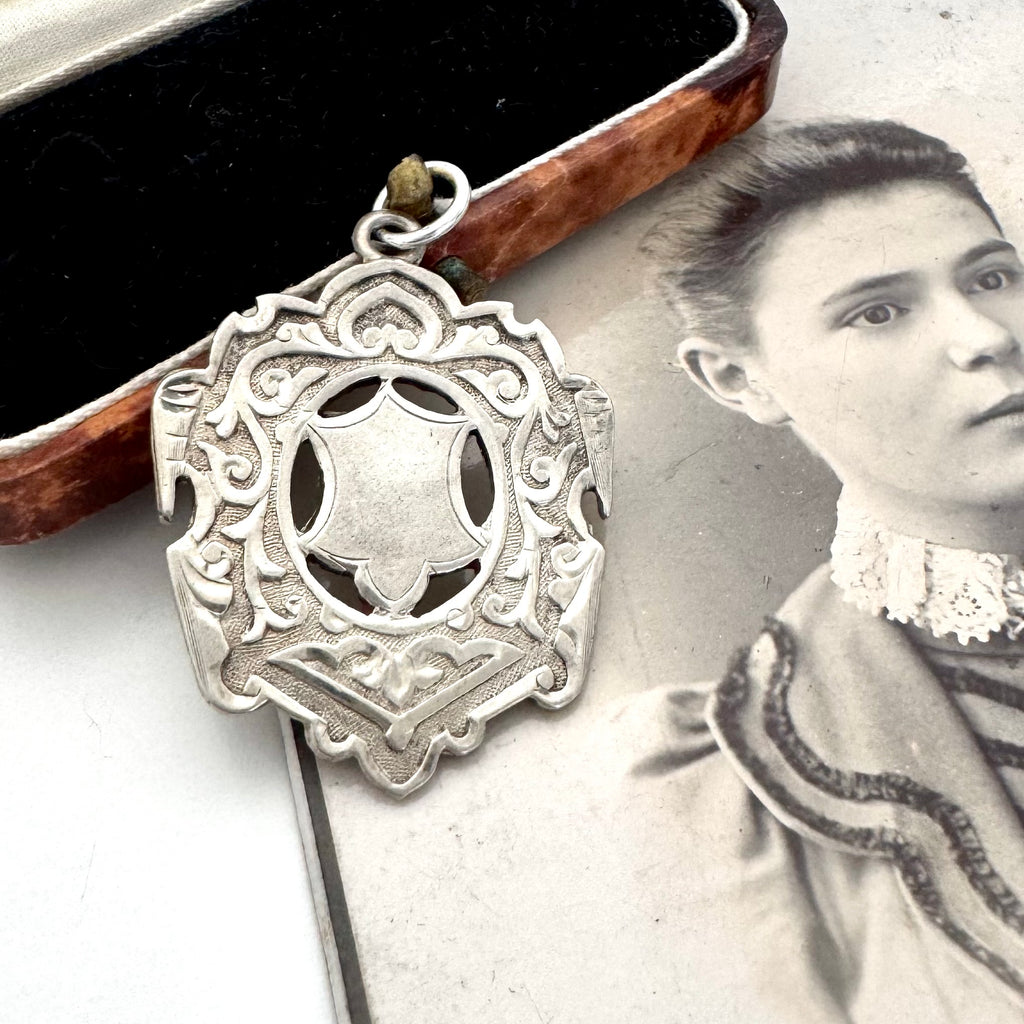 Large antique William Hair Haseler silver watch fob on an old photograph of a woman and jewellery box