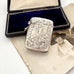 Antique 1911 William Hair Haseler silver vesta case with intricate designs on a vintage photo and box