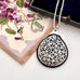Antique silver and tortoiseshell pendant on a decorative card with floral design
