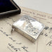 Silver stamp holder on an old letter with 'Tuck's Post Card' text.