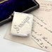 Silver stamp case with 'Stamps' engraving on an old letter