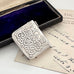 Decorative silver stamp case on an old letter with a dark blue velvet box in the background
