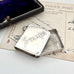 Silver stamp holder with 'STAMPS' engraving on a vintage letter background