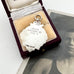 Back of 1929 Fattorini silver watch fob featuring the 3 Lions emblem for Lancashire on a beige cushion in a wooden box
