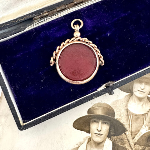 Antique rolled gold carnelian and bloodstone spinning fob on a vintage jewellery box and with an antique photo.