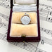 Silver vintage spinning I Love You charm in a jewelry box on sheet music
