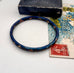 Vintage blue cloisonne bangle on an old jewellery box and vintage postcard