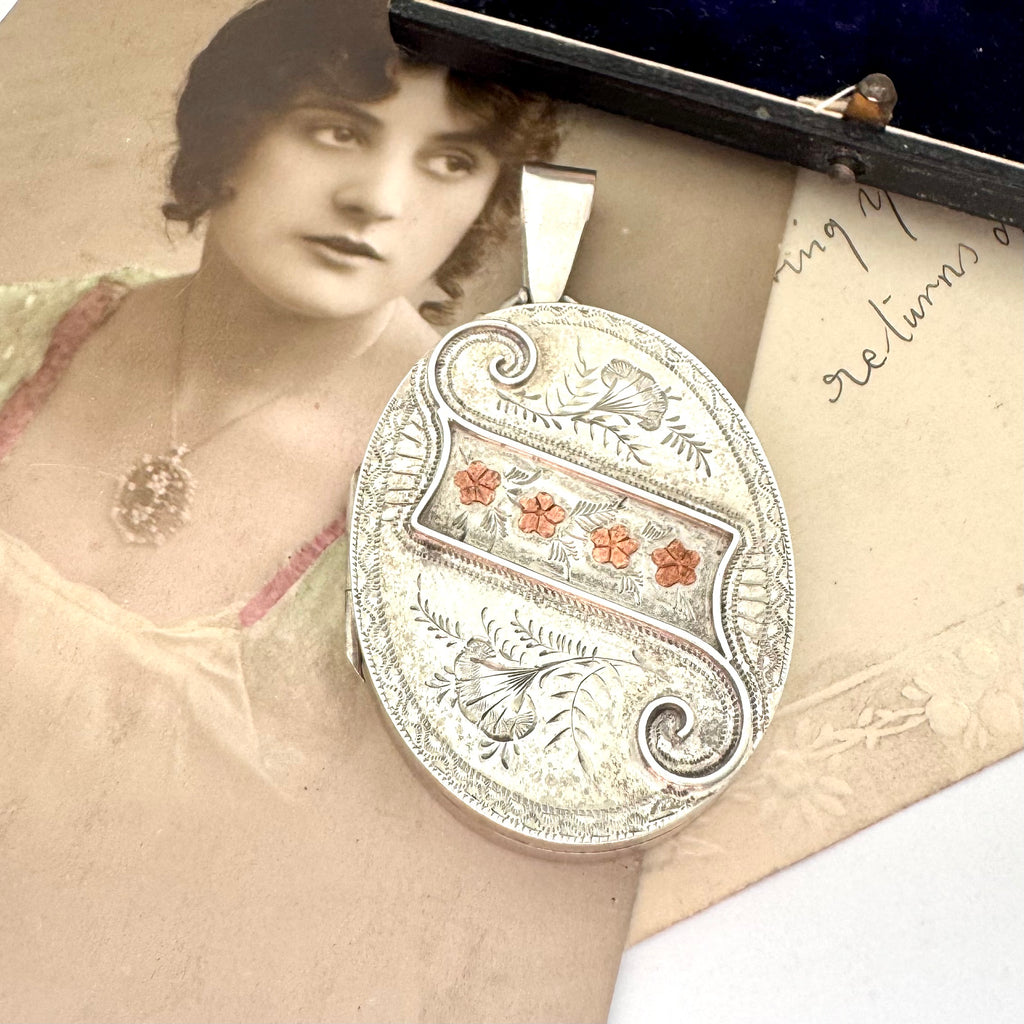 Antique 1885 sterling silver and rose gold locket with an old postcard of a woman.