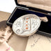 Antique 1885 sterling silver and rose gold locket with an old postcard of a woman and on an old jewellery box