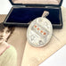 Antique 1885 sterling silver and rose gold locket with an old postcard of a woman and on an old jewellery box.