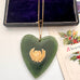 Large New Zealand greenstone and 9ct gold heart pendant on an old jewellery box and with a vintage Christmas card