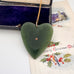 Large New Zealand greenstone and 9ct gold heart pendant on an old jewellery box and with a vintage Christmas card