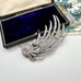 Vintage silver tone bird brooch in a box on a floral background