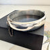 Vonk Jewellery vintage sterling silver half engraved bangle on a black box
