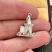 Vintage sterling silver opening church charm on a woman's hand