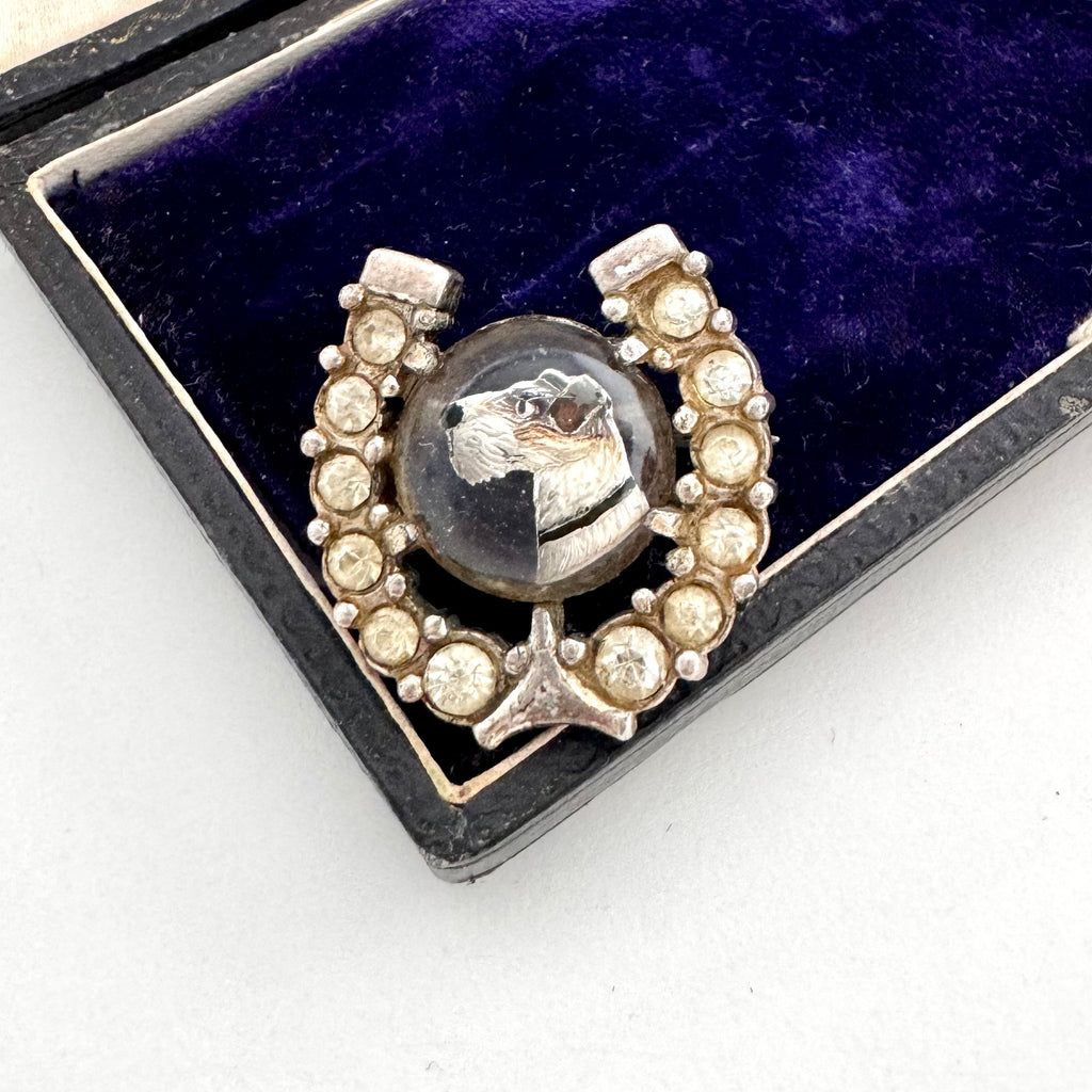 Antique Victorian Essex crystal terrier brooch with paste horseshoe surround on an old jewellery box