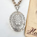 Victorian silver locket with floral design on a white background