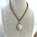 Silver Victorian chain and locket  on a mannequin bust against a light background