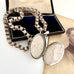 Victorian silver belcher chain with an open decorative locket on a white surface next to an old photograph.