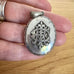Vonk Jewellery Victorian silver Amity, Eternity and Infinity locket on an womans hand